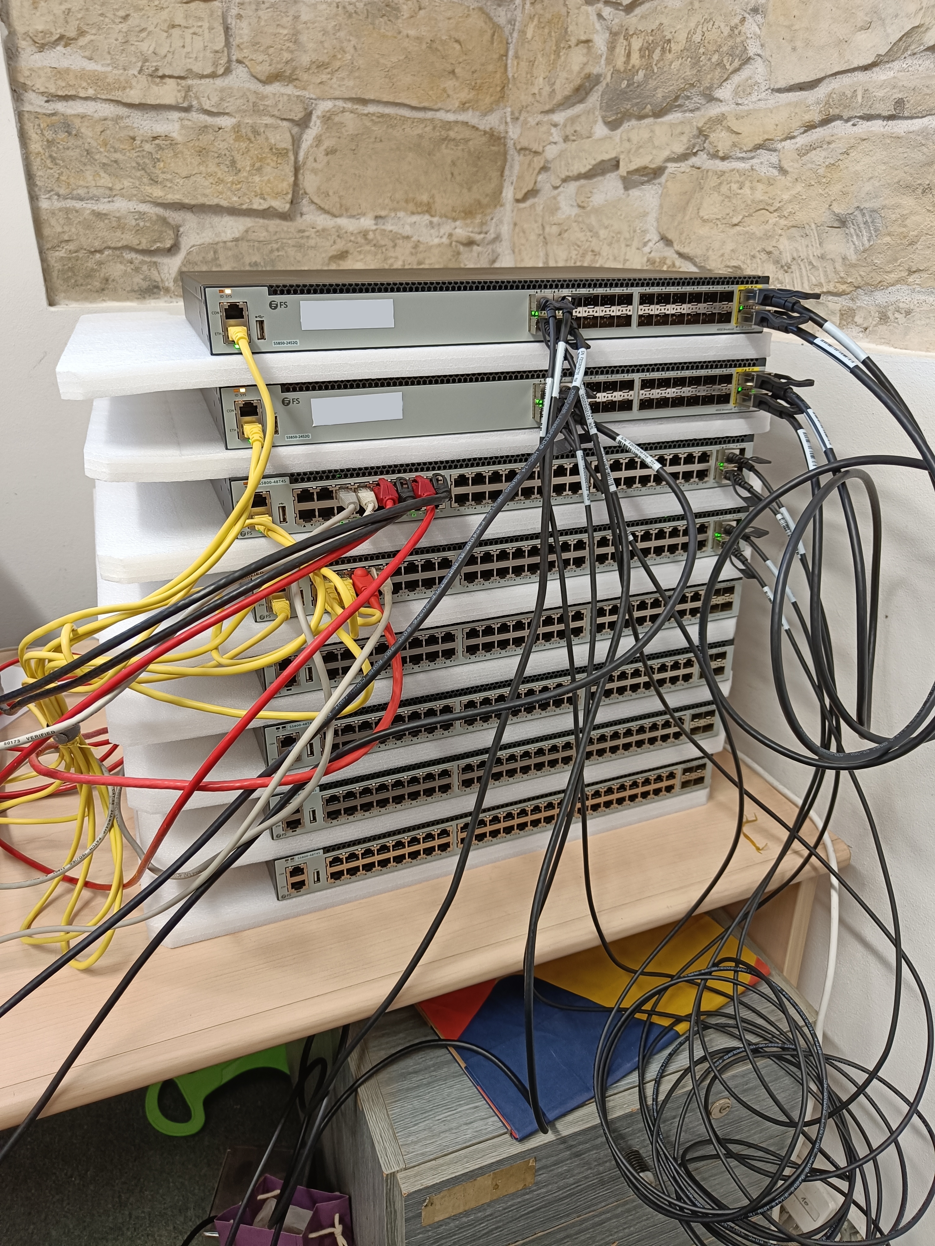 All FiberStore switches, 2 core-switches and 5 access-switches in the lab being prepared for deployment.