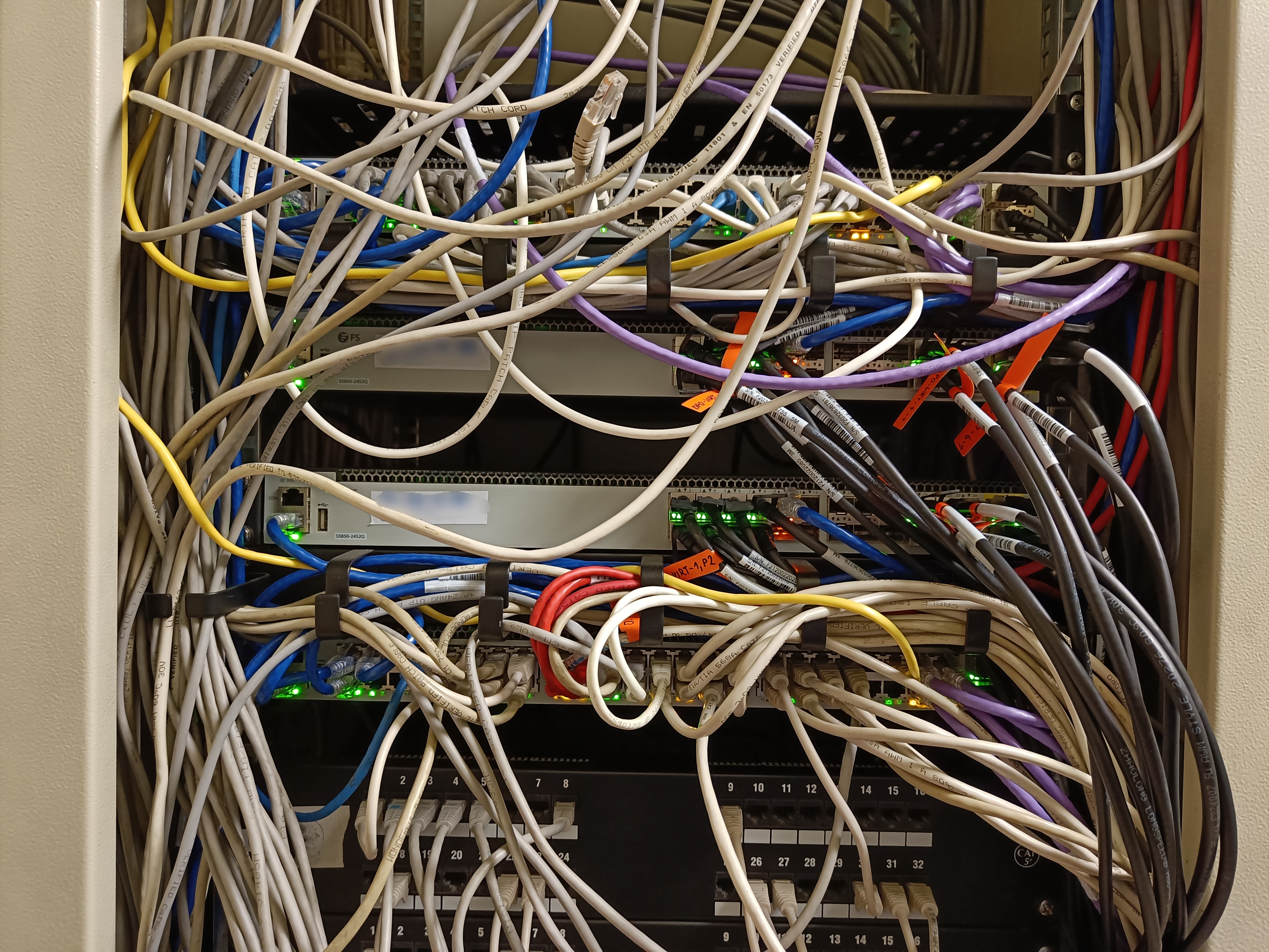 Two FiberStore core-switches surrounded by two access-switches mounted in the rack.
